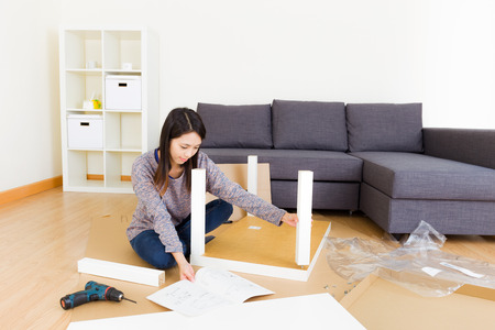 Asian woman assembling new furnitureの写真素材