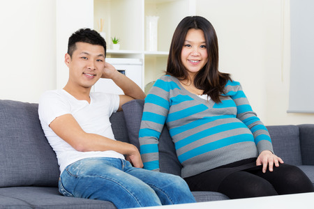 Pregnant woman and husband at homeの写真素材