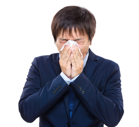 Businessman with allergy sneezingの写真素材