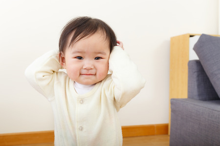 Asian baby girl hand cover her earの写真素材
