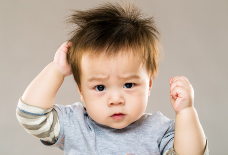 Asian serious kid with grey backgroundの写真素材