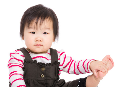 Asian baby girl touch her legの写真素材