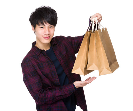 Young man carrying shopping bagの写真素材