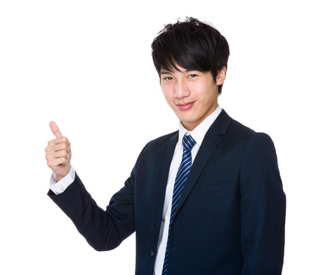 Happy young handsome business man show thumb upの写真素材