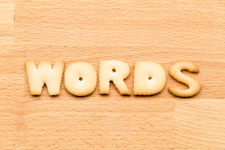 Letter words biscuit over the wooden backgroundの写真素材