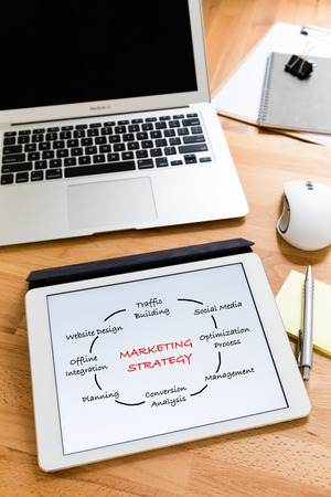 Business working desk with tablet showing marketing Strategy conceptの写真素材
