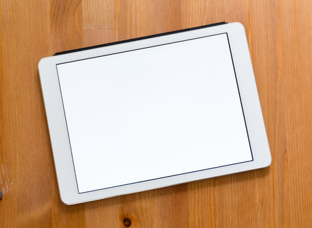 Digital Tablet on a desk and showing a blank screen for advertistingの写真素材