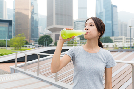 Sport Woman drink with green beverage at outdoorの写真素材
