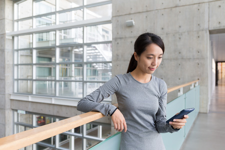 Woman checking something on cellphone at indoorの写真素材
