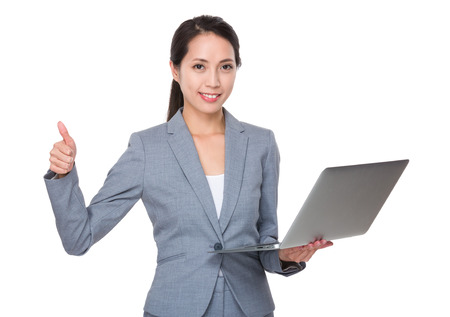 Asian Young Businesswoman use of the notebook computer and thumb upの写真素材