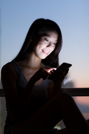 Asian Woman use of the cellphone at homeの写真素材