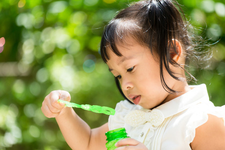 Cute girl play with bubble blowerの写真素材