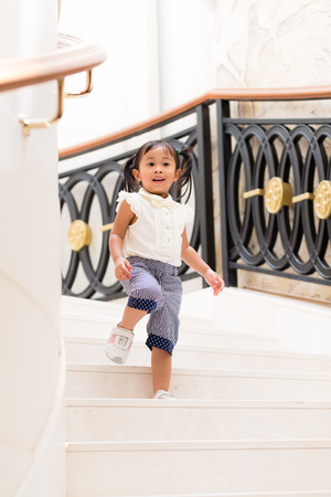 Little girl walking downstairの写真素材