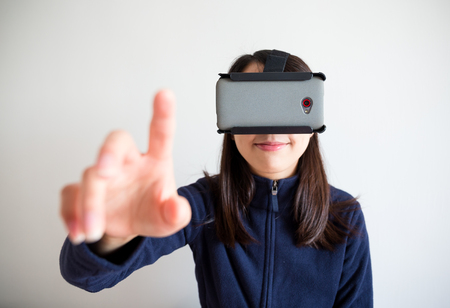 Woman look though vr device and touch on airの写真素材
