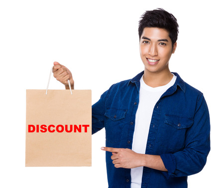Man finger point to shopping bag for showing a word discountの写真素材