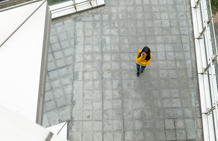 Asian Woman chatting to mobile phone on streetの写真素材