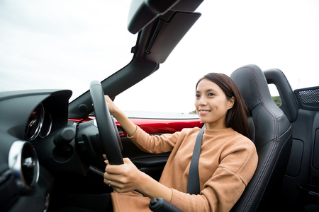 Young Woman driving convertible carの写真素材