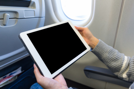 Woman use of the digital tablet in planeの写真素材