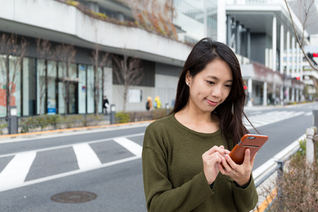 Young Woman using cellphone at outdoorの写真素材