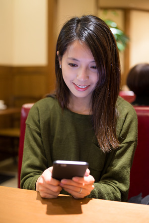 Young woman use of cellphone in cafeの写真素材