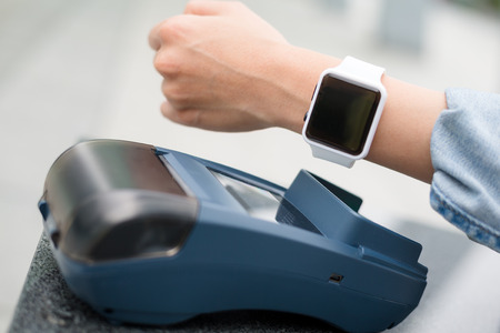 Woman using smart watch pay on pos machineの写真素材