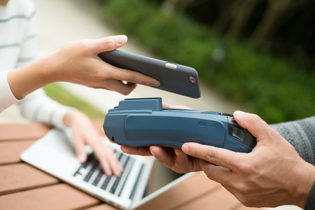 Woman pay by cellphone on pos machineの写真素材