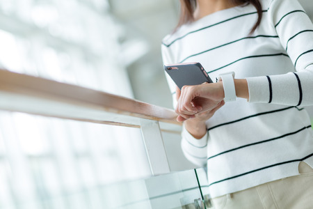 Woman using smartwatch and coneecting to her mobile phoneの写真素材