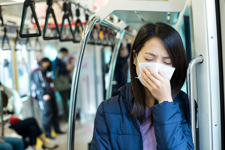 Passenger feeling unwell with face mask inside train compartmentの写真素材