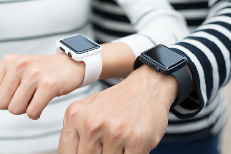 Couple connecting smart watch together at outdoor