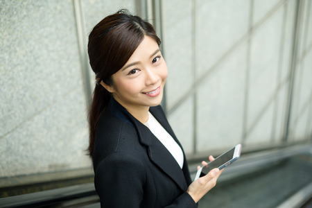 Businesswoman standing on escalatorの写真素材