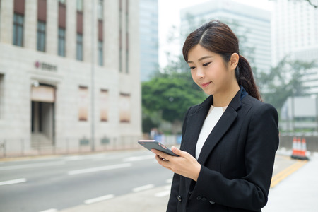 Businesswoman sending sms on mobile phoneの写真素材