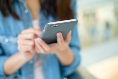Woman sending message with smartphoneの写真素材