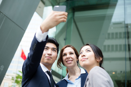 Business people taking self photo togetherの写真素材