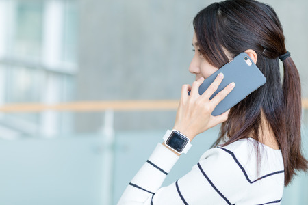 Woman chat on mobile phone and wearing smart watchの写真素材