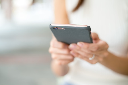 Close up of woman sending sms on mobile phoneの写真素材