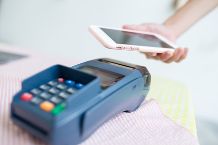 Female paying with NFC technology on smart phoneの写真素材