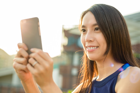 Woman using cellphone at outdoorの写真素材