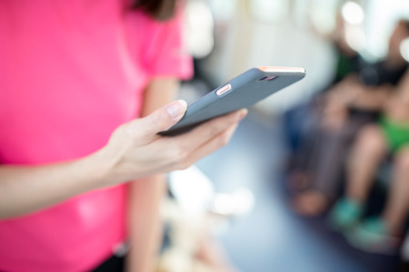 Woman hold with smart phone inside train compartment