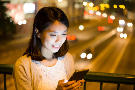 Woman use of cellphone at nightの写真素材