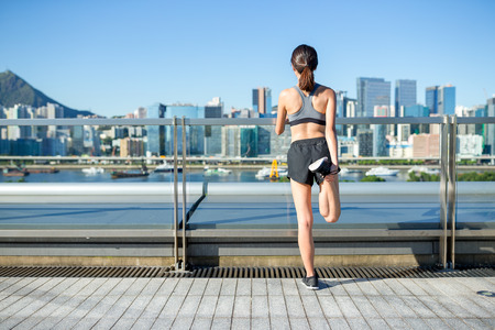 Sports woman doing stretching legs before running