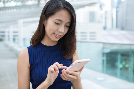 Woman using mobile phone at outdoorの写真素材