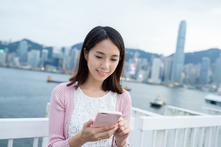 Woman using cellphone in Hong Kongの写真素材
