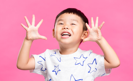 Excited little boy showing grimaceの写真素材