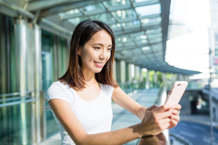 Woman sending sms on mobile phoneの写真素材