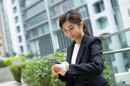 Businesswoman use cellphone and smart watchの写真素材
