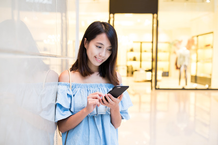 Woman sending sms on cellphoneの写真素材