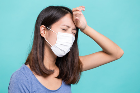 Woman wearing face mask and suffer from headacheの写真素材