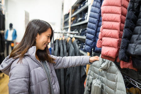 Woman choosing clothes in mallの写真素材