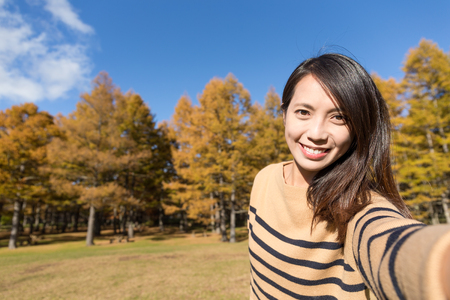 Woman holding digital camera to take selfieの写真素材