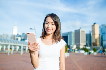Woman using smart phone in Hong Kongの写真素材